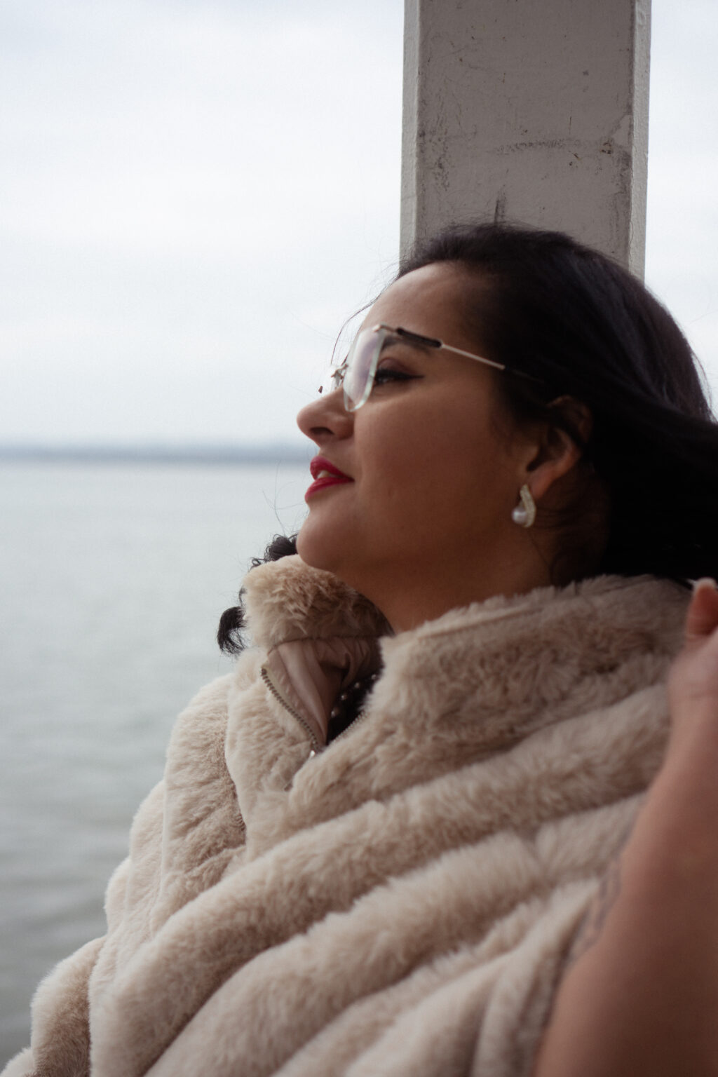 Juliem Rechmann im hellen Mantel am See